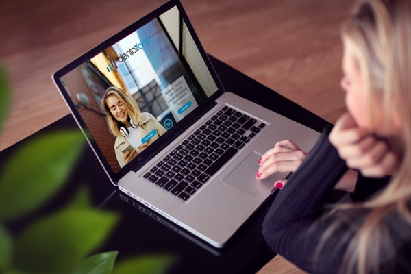 A person browsing the Dentalfone website on a laptop.