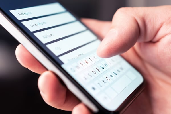 A person uses a cell phone to fill out an online contact form.
