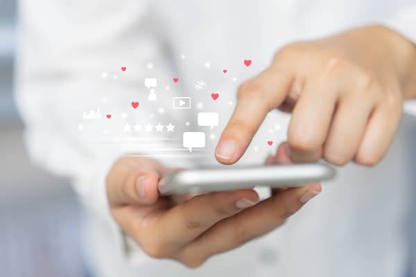 A person uses a mobile phone to browse and interact with social media.